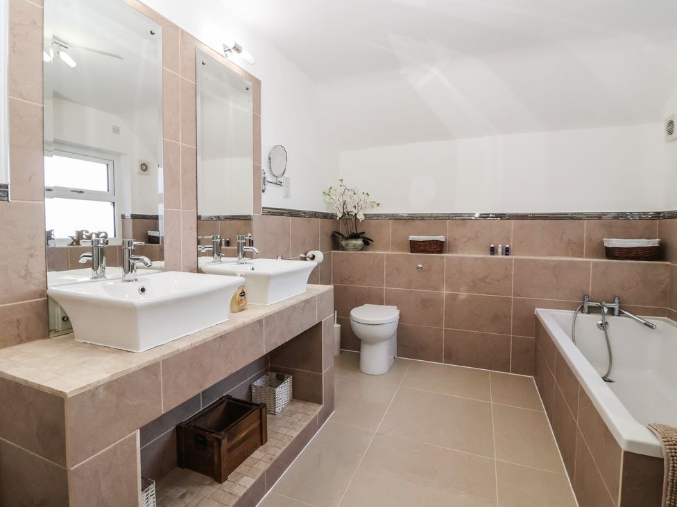 A bathroom with two sinks and a bathtub at Ten Gables in Driffield