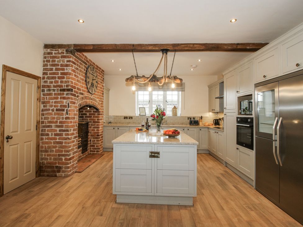A kitchen with an island and refrigerator at Highfields Farm Church Preen near Much Wenlock
