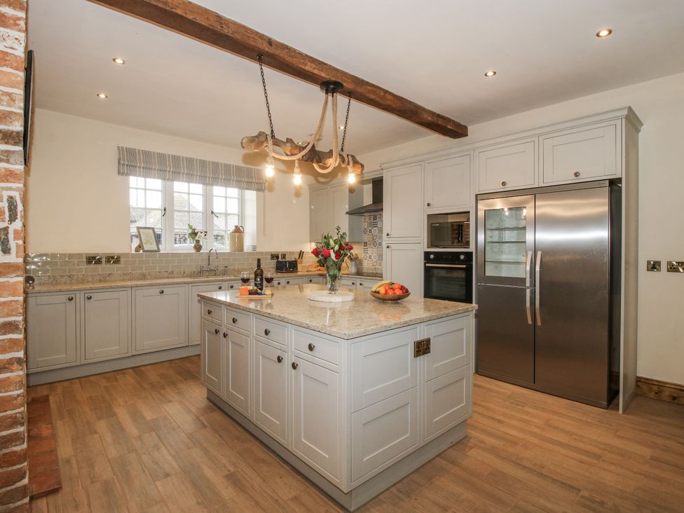 A kitchen with an island, stainless steel fridge, and oven at Highfields Farm, Church Preen near Much Wenlock