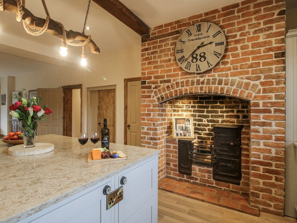 A kitchen with a fireplace and kitchen island at Highfields Farm Church Preen near Much Wenlock