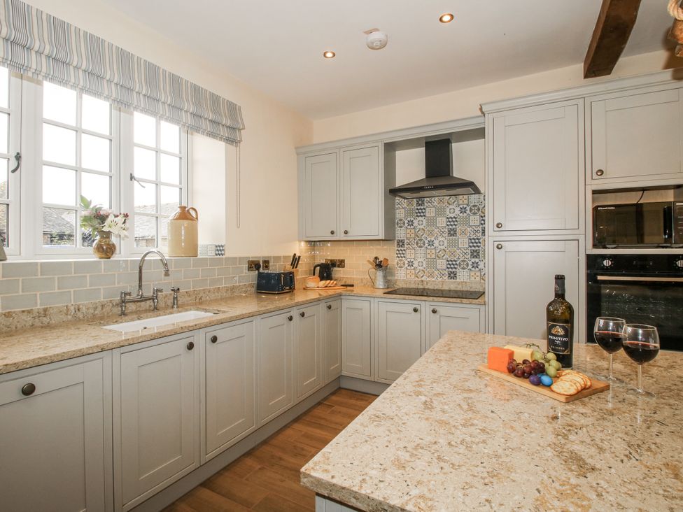 A kitchen with a sink, countertop, and wine glasses at Highfields Farm Church Preen near Much Wenlock