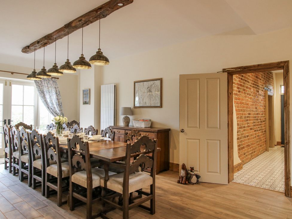 A dining room with a long table and chairs at Highfields Farm Church Preen near Much Wenlock