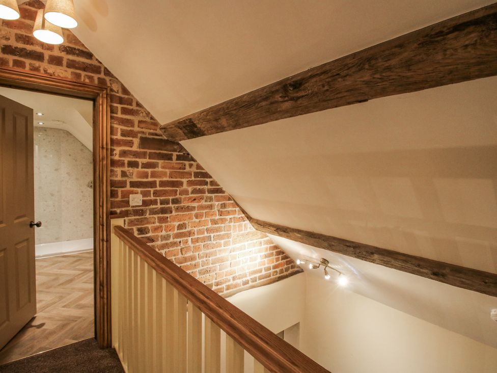 A hallway with brick wall and wood beams at Highfields Farm Church Preen near Much Wenlock