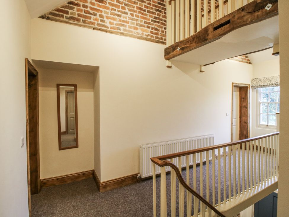 A hallway with a mirror and a radiator at Highfields Farm Church Preen near Much Wenlock