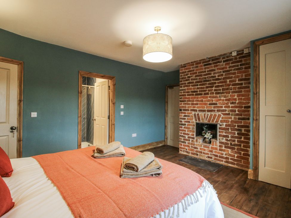 A bedroom with a bed and a brick wall feature at Highfields Farm in Church Preen near Much Wenlock