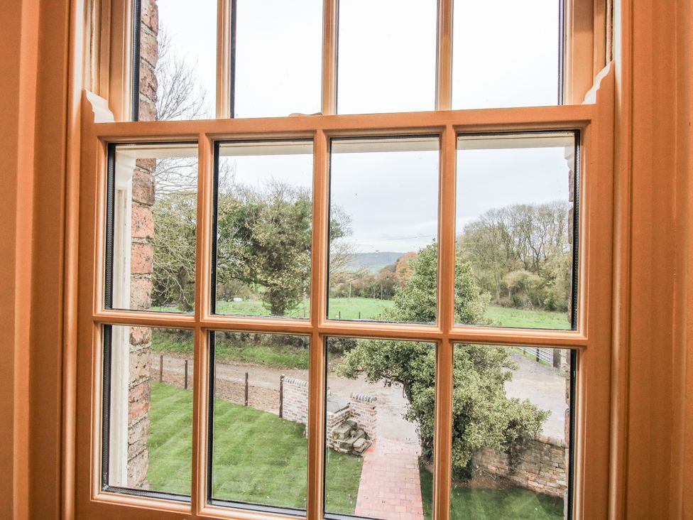 A window view showing grass, trees and a pathway at Highfields Farm Church Preen near Much Wenlock