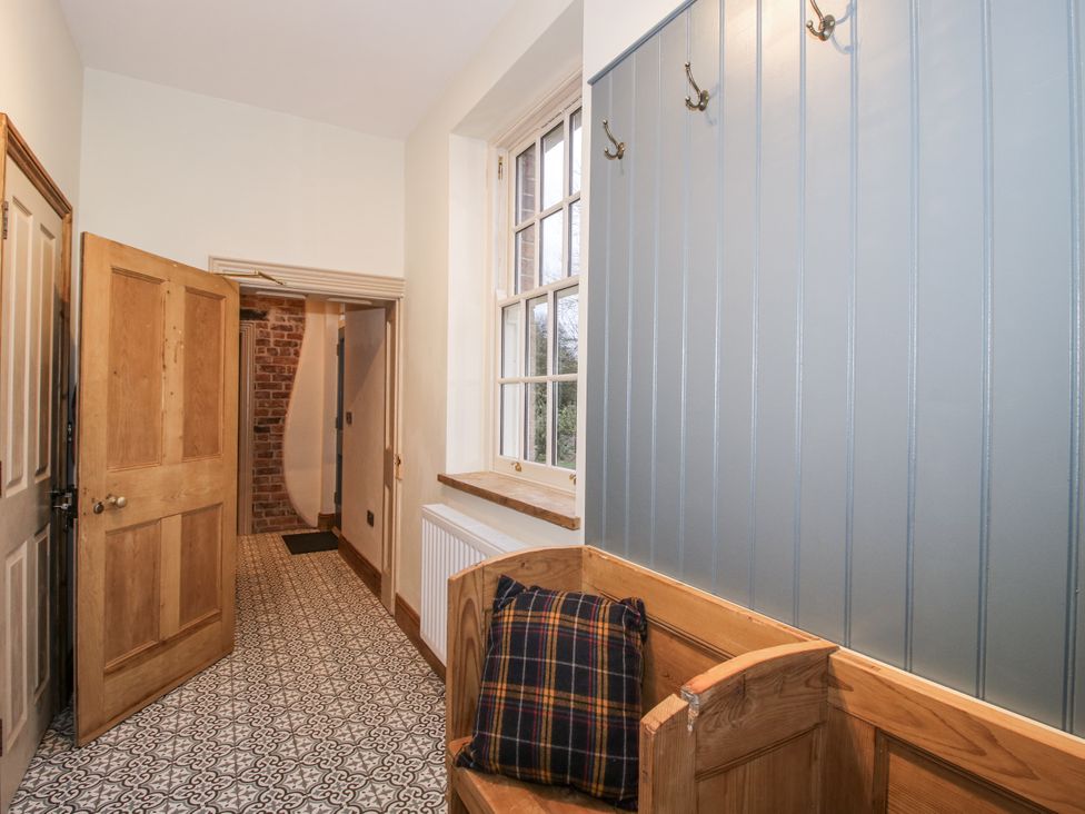 A hallway with a bench and a large window at Highfields Farm near Church Preen