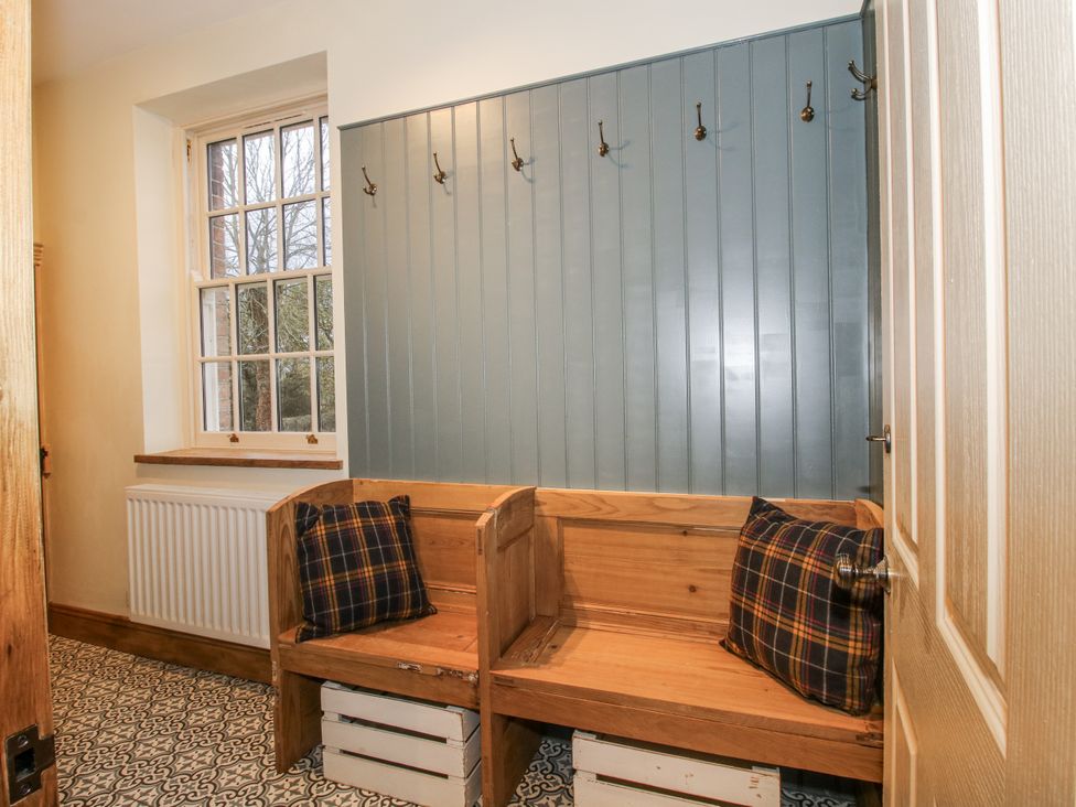 A hallway with a bench and hooks at Highfields Farm Church Preen near Much Wenlock