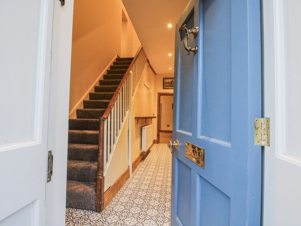 A hallway with a staircase and a blue front door at Highfields Farm, Church Preen near Much Wenlock
