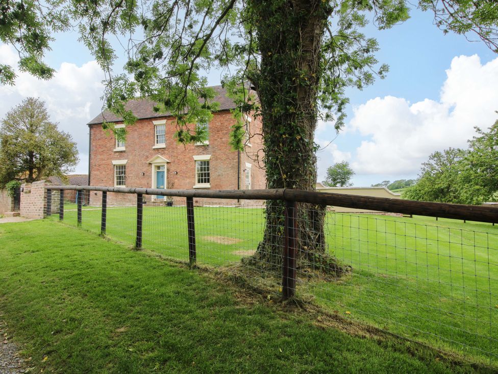 A house with a fence and tree outside at Highfields Farm in Church Preen near Much Wenlock