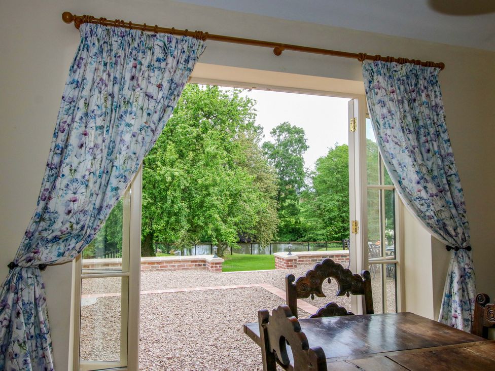 A dining room with a view of the garden at Highfields Farm Church Preen near Much Wenlock