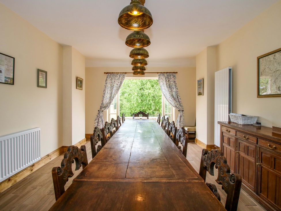 A dining room with a long table and chairs at Highfields Farm Church Preen near Much Wenlock