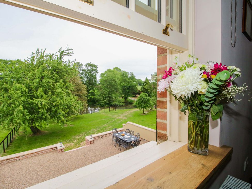 A window with flowers and a view of a garden at Highfields Farm in Church Preen near Much Wenlock