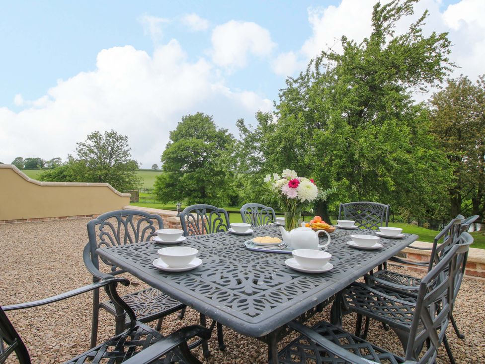 An outdoor dining area with a table and chairs at Highfields Farm in Church Preen near Much Wenlock
