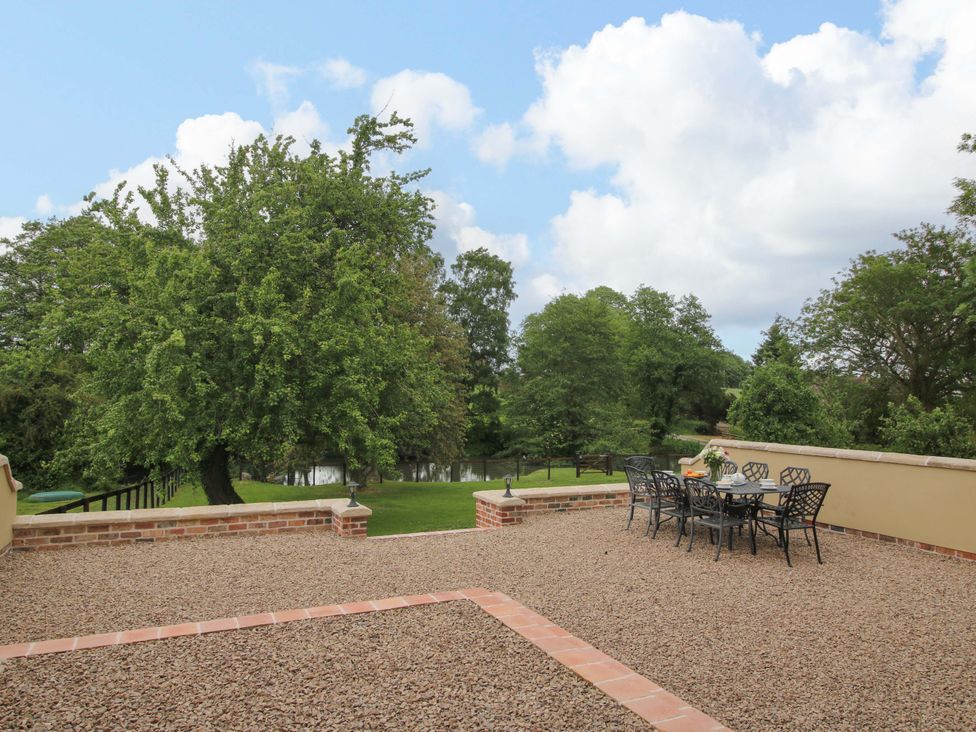 An outdoor patio with a table and chairs overlooking a garden at Highfields Farm near Church Preen