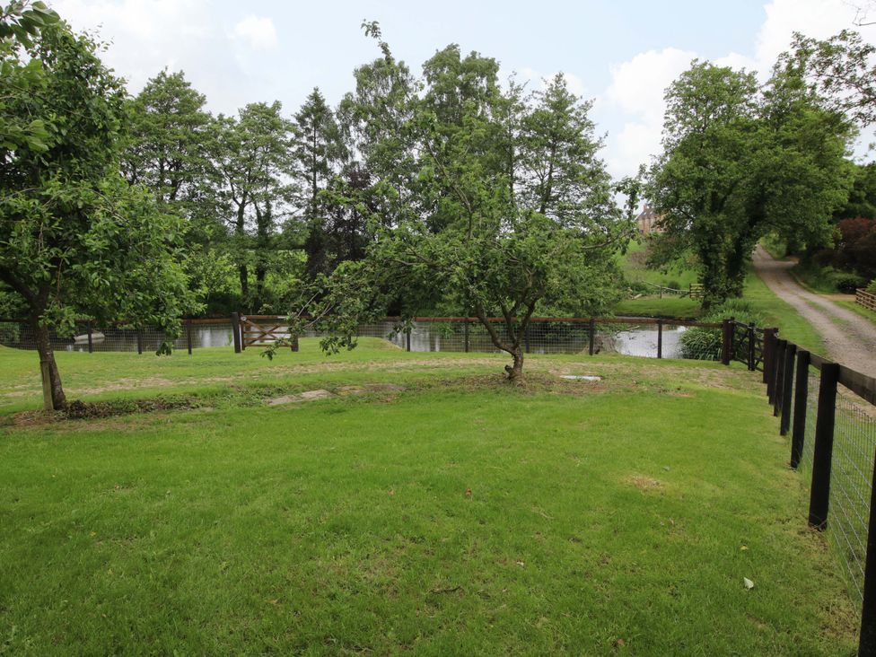 A garden area with trees and a pathway at Highfields Farm in Church Preen near Much Wenlock