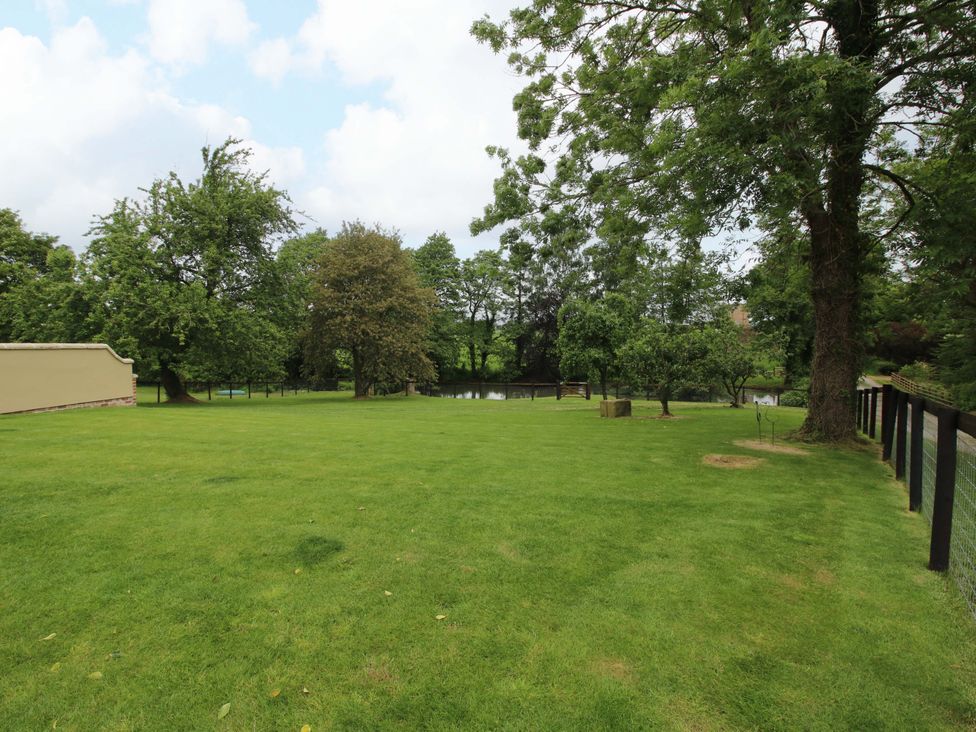 A garden with trees and a fence at Highfields Farm in Church Preen near Much Wenlock