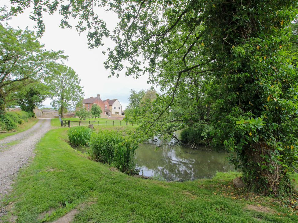 A view of a path leading to a house by a pond at Highfields Farm in Church Preen near Much Wenlock