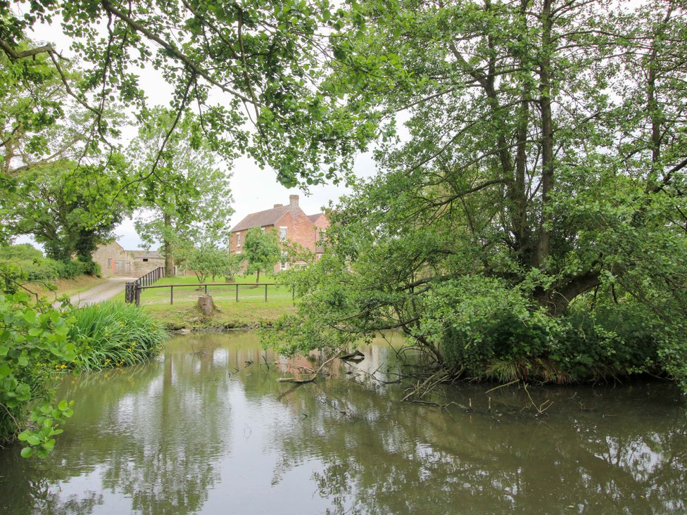 A view of a house beside water at Highfields Farm Church Preen near Much Wenlock