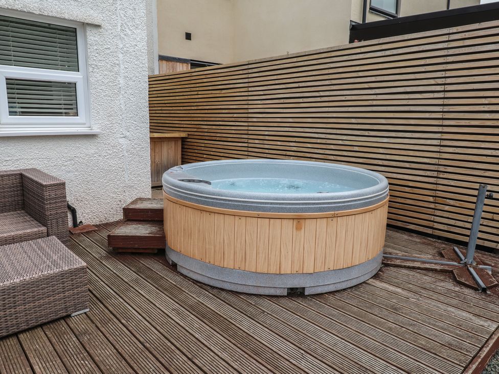 An outdoor area with a hot tub and seating at 51 Trinity Avenue Llandudno