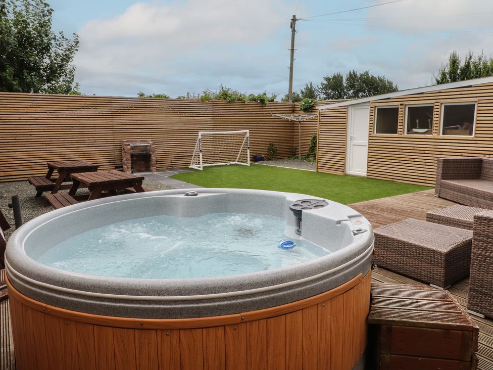 A garden with a hot tub and dining area at 51 Trinity Avenue, Llandudno