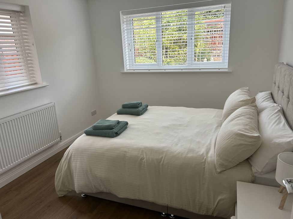 A bedroom with a bed and towels at 40 Gloddaeth View in Penrhyn Bay