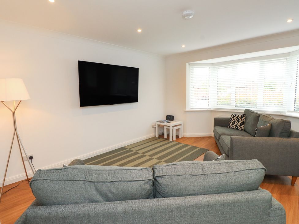 A living room with a sofa and television at 40 Gloddaeth View Penrhyn Bay