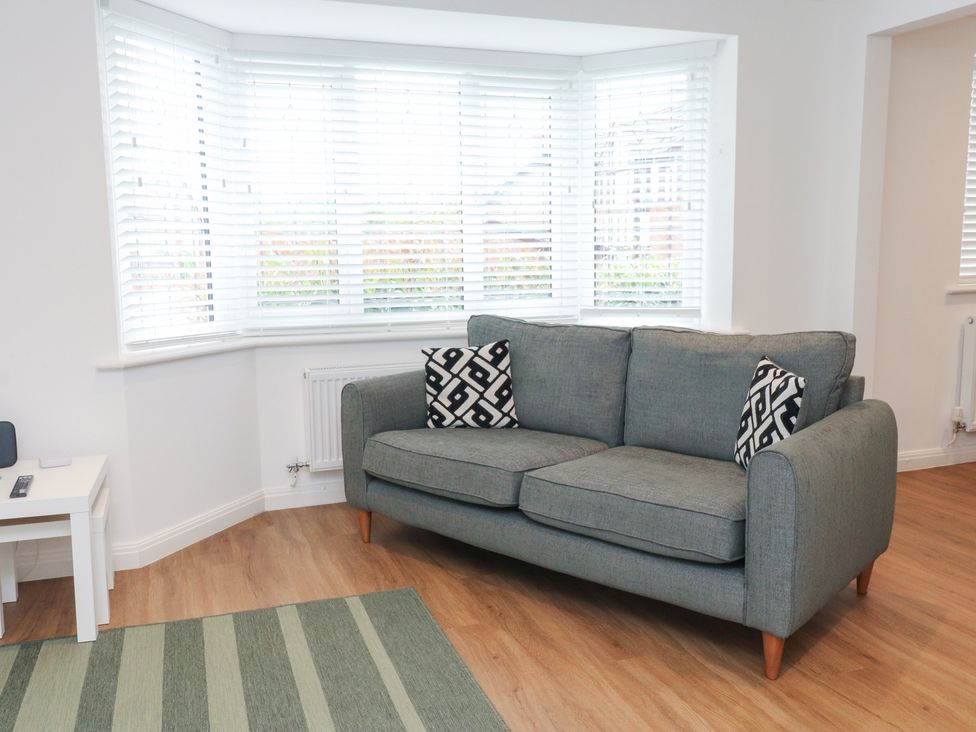 A living room with a sofa and cushions at 40 Gloddaeth View Penrhyn Bay