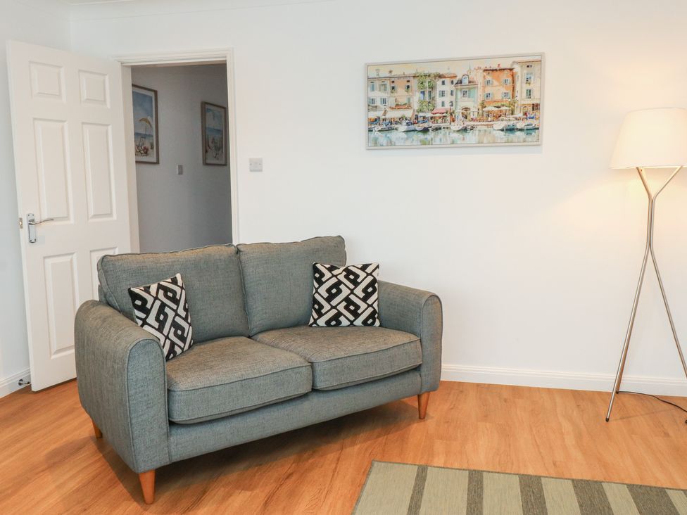 A living room with a grey sofa and artwork at 40 Gloddaeth View Penrhyn Bay