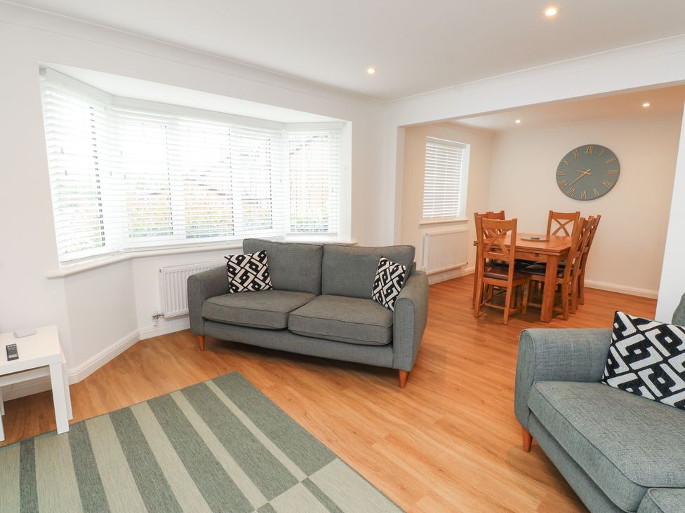 A living room with a sofa and dining table at 40 Gloddaeth View Penrhyn Bay