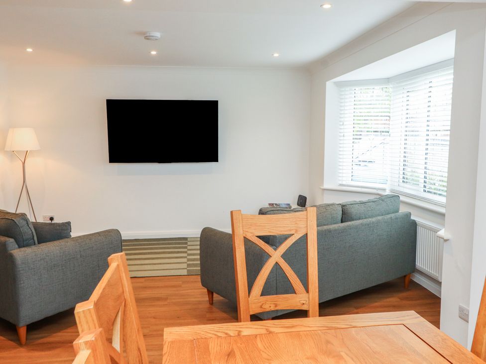 A living room with a sofa and television at 40 Gloddaeth View Penrhyn Bay