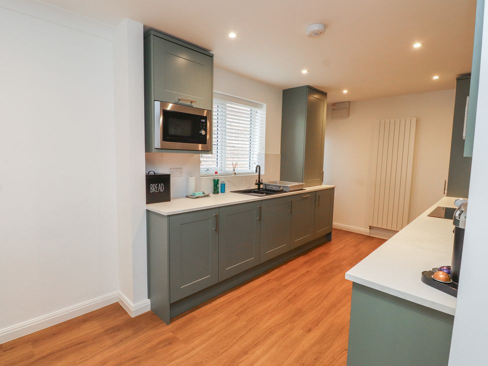 A kitchen with a sink and microwave at 40 Gloddaeth View Penrhyn Bay