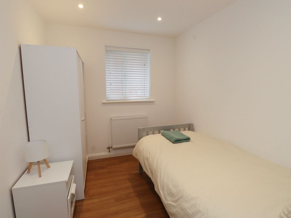 A bedroom with a bed and wardrobe at 40 Gloddaeth View Penrhyn Bay