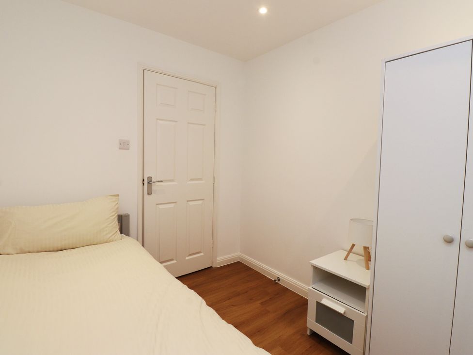 A bedroom with a bed and wardrobe at 40 Gloddaeth View Penrhyn Bay