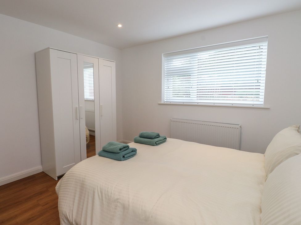 A bedroom with a bed and wardrobe at 40 Gloddaeth View in Penrhyn Bay