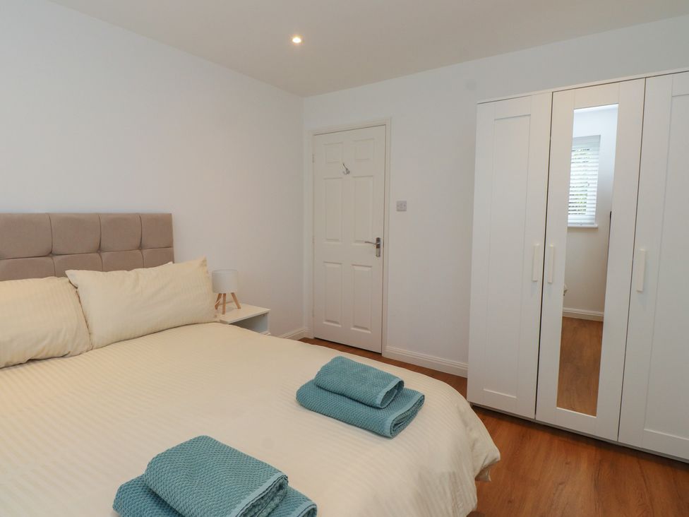 A bedroom with a bed and wardrobe at 40 Gloddaeth View Penrhyn Bay