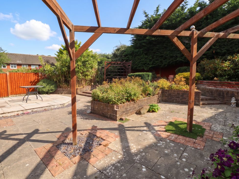 A garden with a table and flower bed at 40 Gloddaeth View Penrhyn Bay