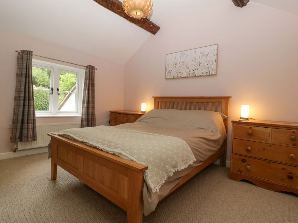 A bedroom with a bed and nightstand at 2 Loxter Villas Wellington Heath near Ledbury
