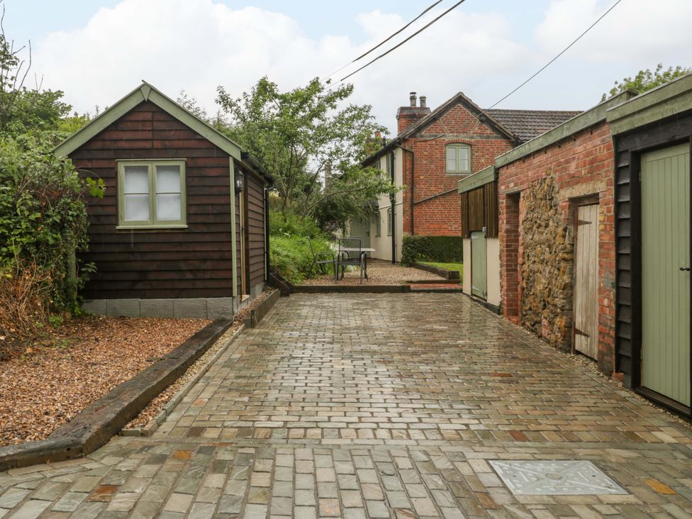 An outdoor area with a paved driveway and garden shed at 2 Loxter Villas Wellington Heath near Ledbury