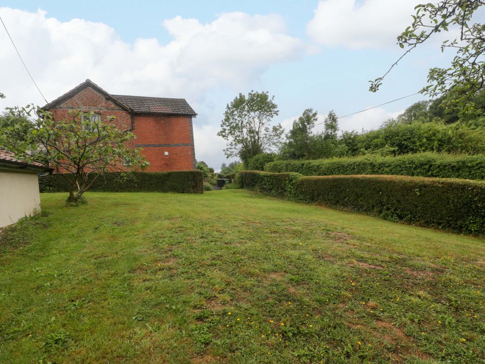 A garden view with a house and trees at 2 Loxter Villas in Wellington Heath near Ledbury