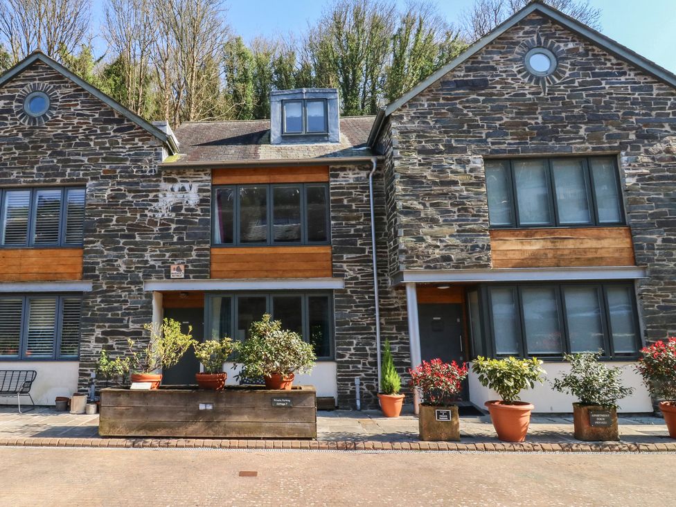 Exterior view of a stone house with planters at 8 Pottery Cottages