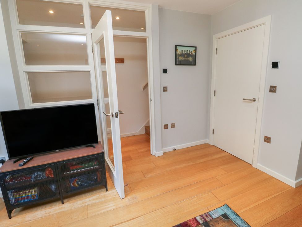 A living room with a television and cabinet at 8 Pottery Cottages