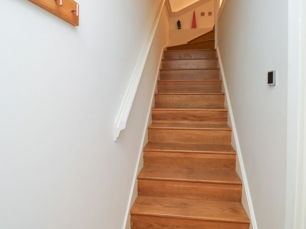 A staircase with wooden steps and a handrail at 8 Pottery Cottages
