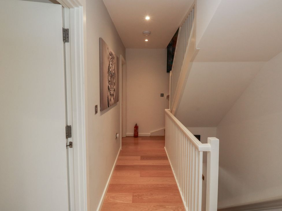 A hallway with a fire extinguisher and wall art at 8 Pottery Cottages