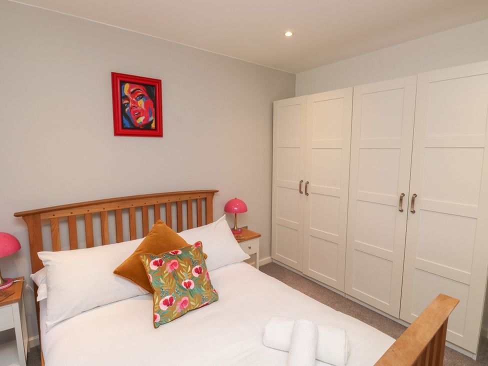 A bedroom with a bed and wardrobe at 8 Pottery Cottages 
