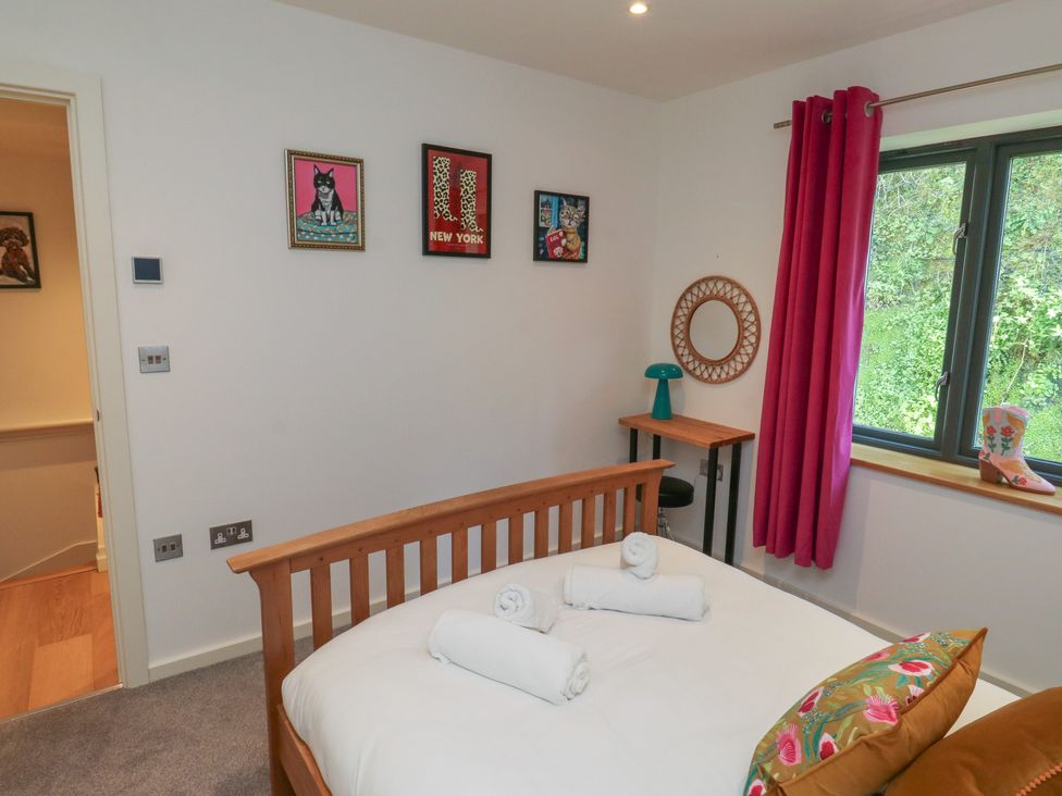 A bedroom with a bed and artworks on the wall at 8 Pottery Cottages 