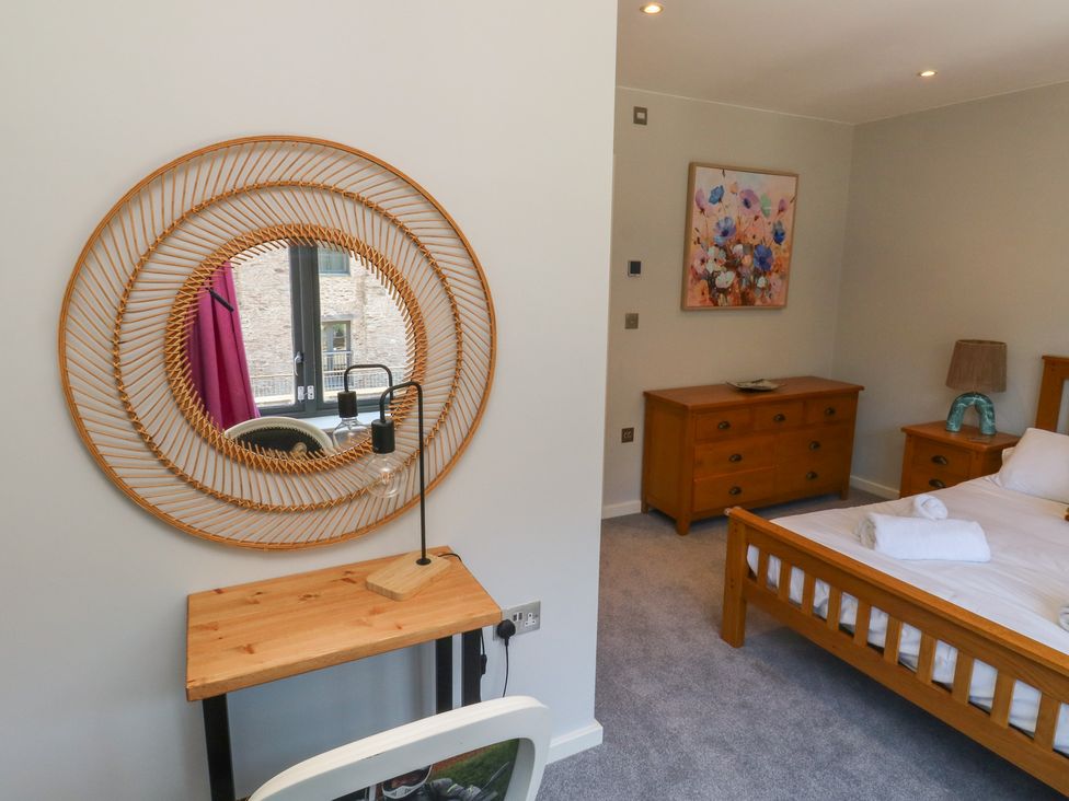 A bedroom with a bed and dresser at 8 Pottery Cottages