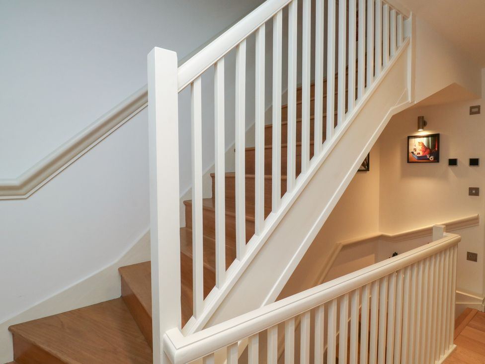 A staircase with wooden steps and a handrail at 8 Pottery Cottages
