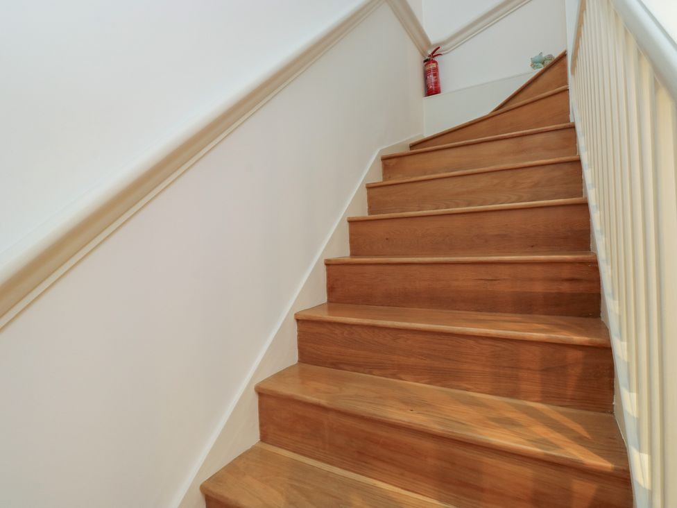 A staircase with wooden steps and a fire extinguisher at 8 Pottery Cottages in 