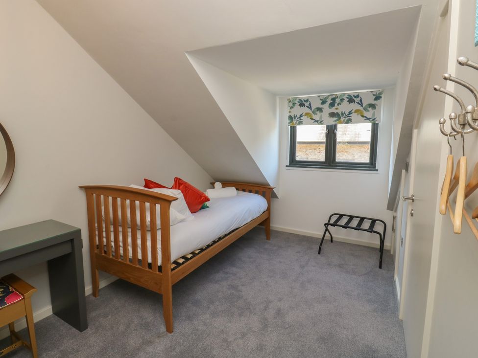 A bedroom with a single bed and desk at 8 Pottery Cottages